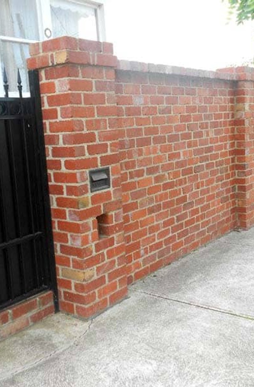 Red brick front fence with pillars, metal gate and integrated letterbox